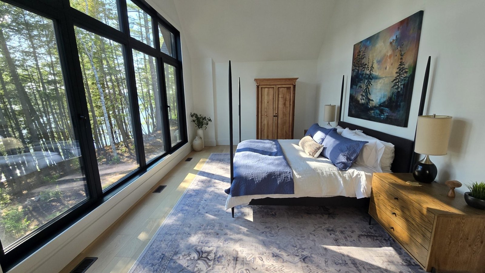 Bedroom with vaulted ceiling and floor-to-ceiling lake-view windows