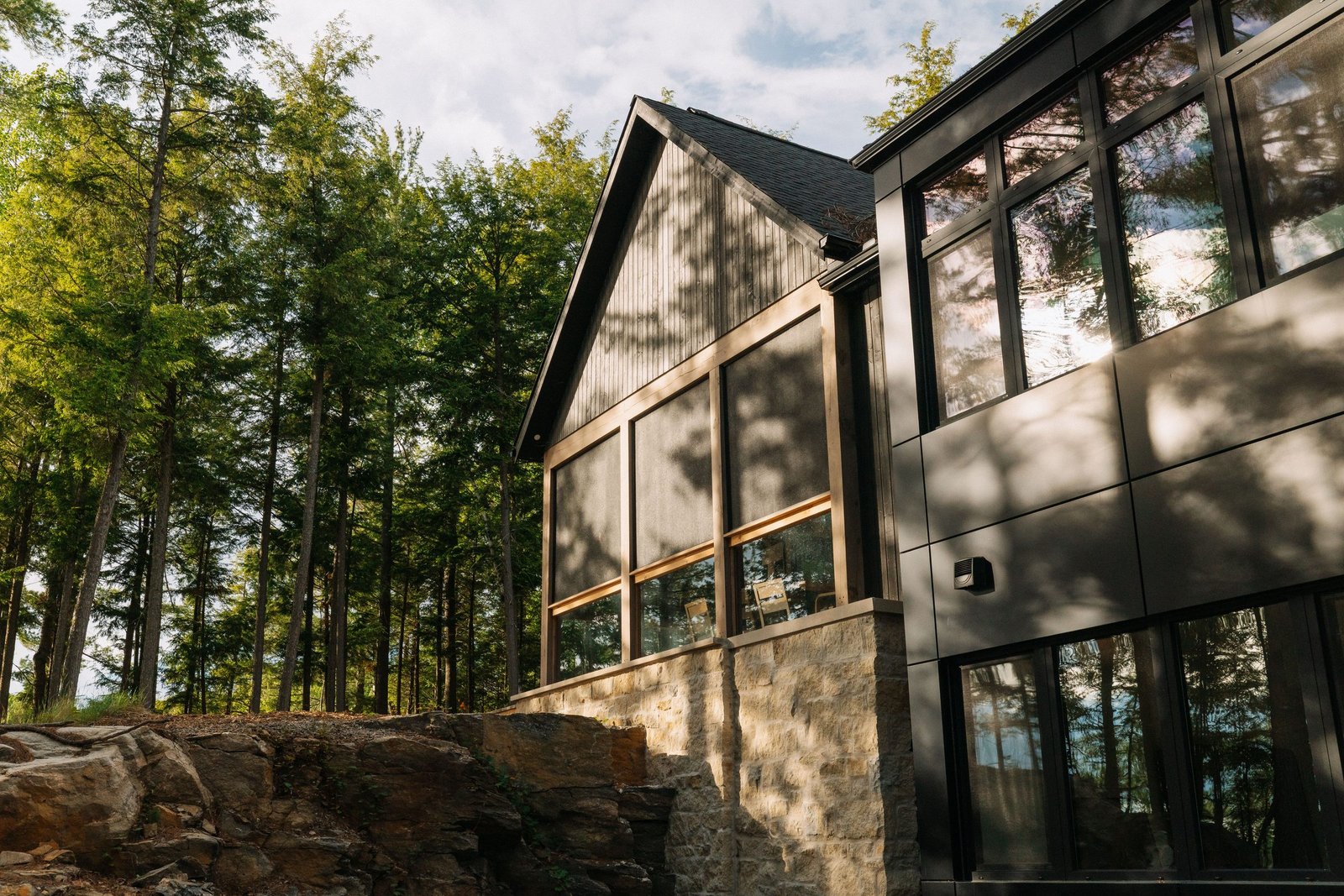 Detail of the cottage's timber, stone, and glass facade