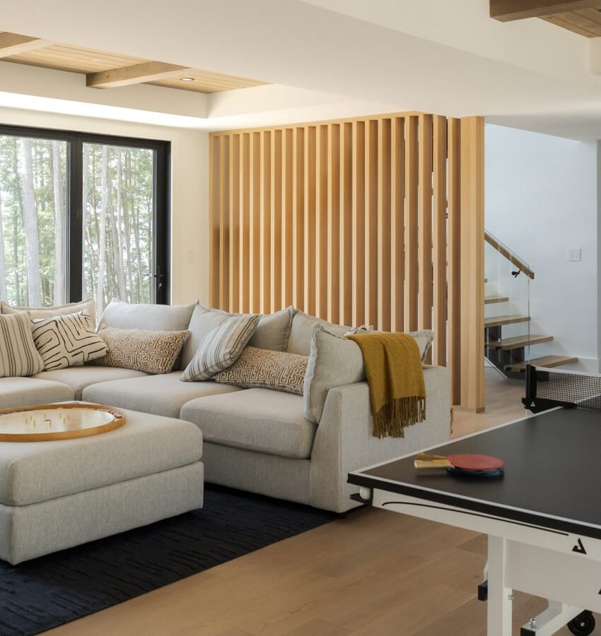 Lower-level rec room with sectional sofa and ping pong table